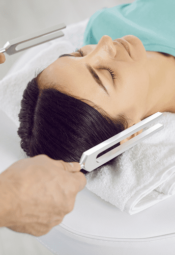 Tuning forks therapy on a woman's head.